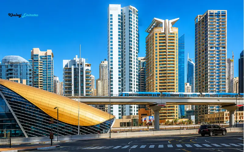 Dubai Investment Park 1 Metro Station with elevated Dubai Metro train and city skyline